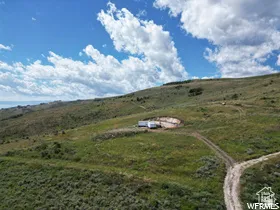 Expansive undeveloped land featuring natural terrain and a partial dirt road