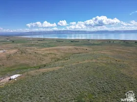 Expansive undeveloped land featuring natural terrain and distant water body