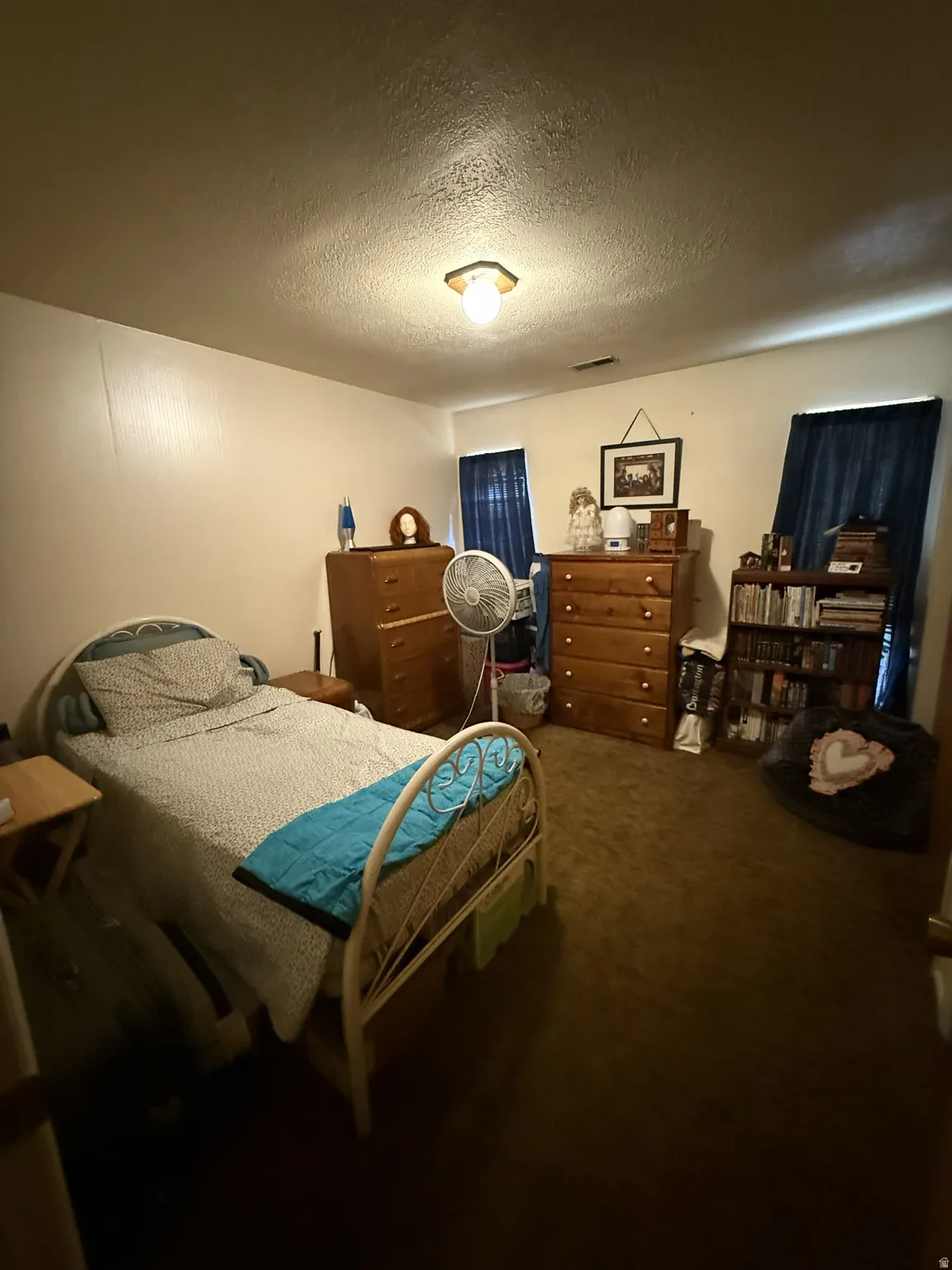 Room featuring textured white walls and brown carpeting