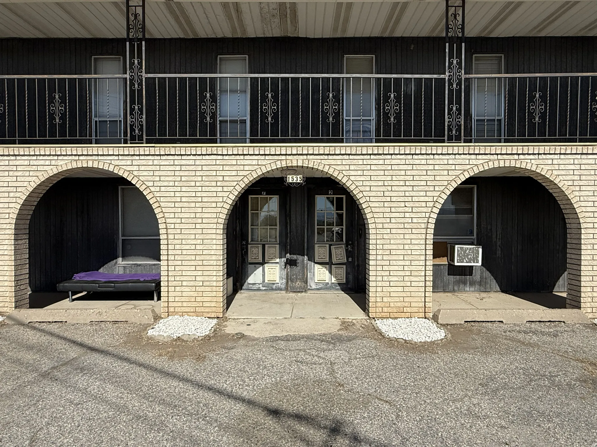 Two-story exterior featuring a light-colored brick archway facade