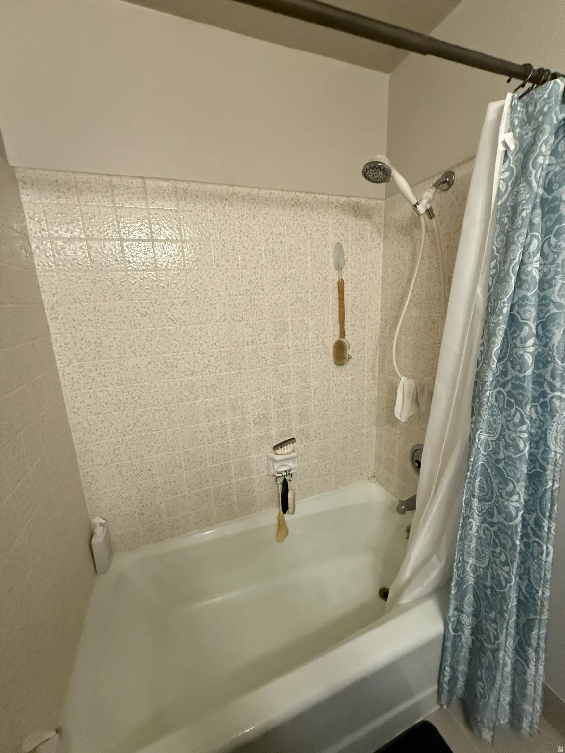 White porcelain bathtub with a handheld shower fixture