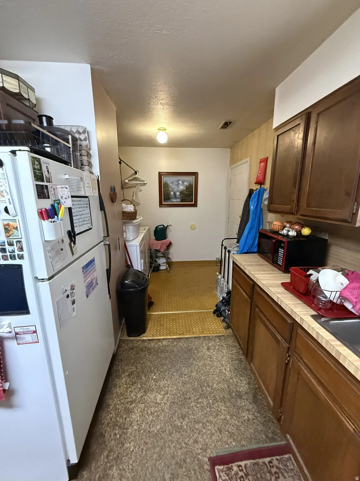 Kitchen space featuring laminate countertops, wood cabinetry, and a stainless steel sink