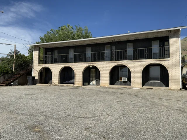 Two-story building featuring a brick facade on the lower level with arched openings