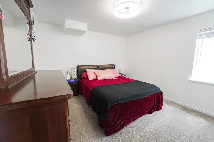 Carpeted room with a flush-mount ceiling light fixture, a window with a white blind, and white walls