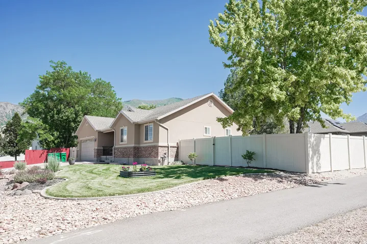 Split-level residence featuring a stucco and stone veneer facade with a two-car garage