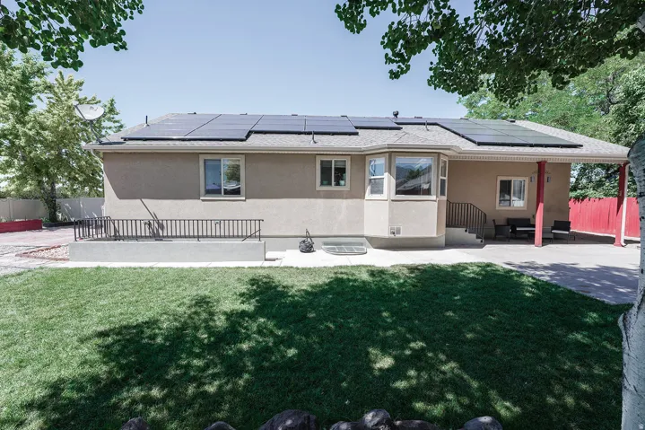 Stucco exterior with a bay window, covered patio, and ground-level concrete patio