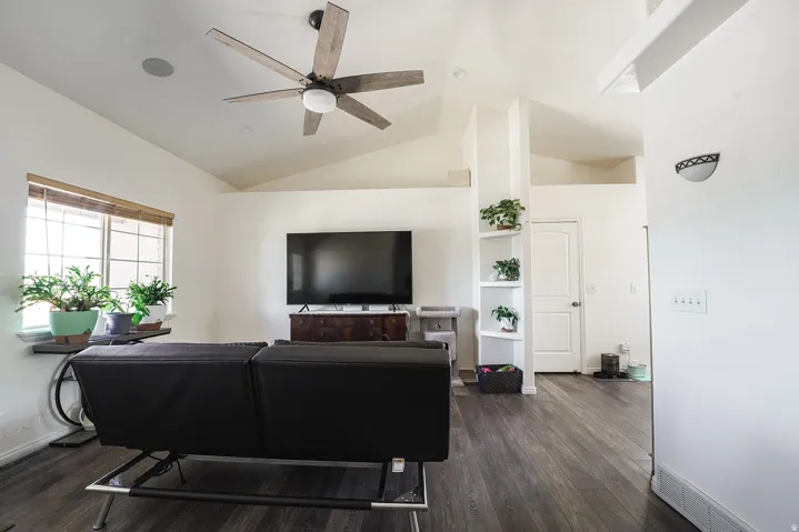 Vaulted ceiling with a wood-finish ceiling fan and recessed lighting