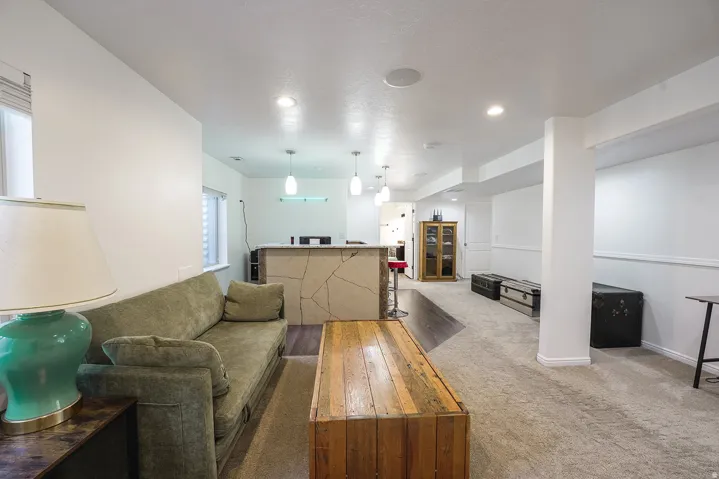 Spacious open-concept room featuring recessed lighting and a built-in bar with pendant lights