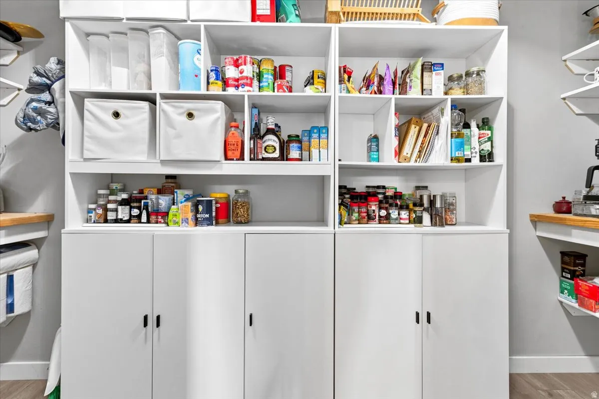 Built-in white cabinetry featuring open shelving, enclosed storage, and a light-colored countertop surface