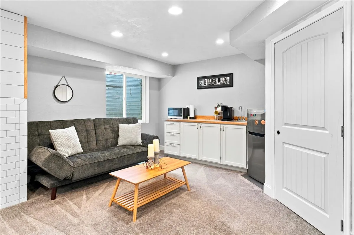 Bar/small kitchenette with working sink. Door leads to storage under staircase.
