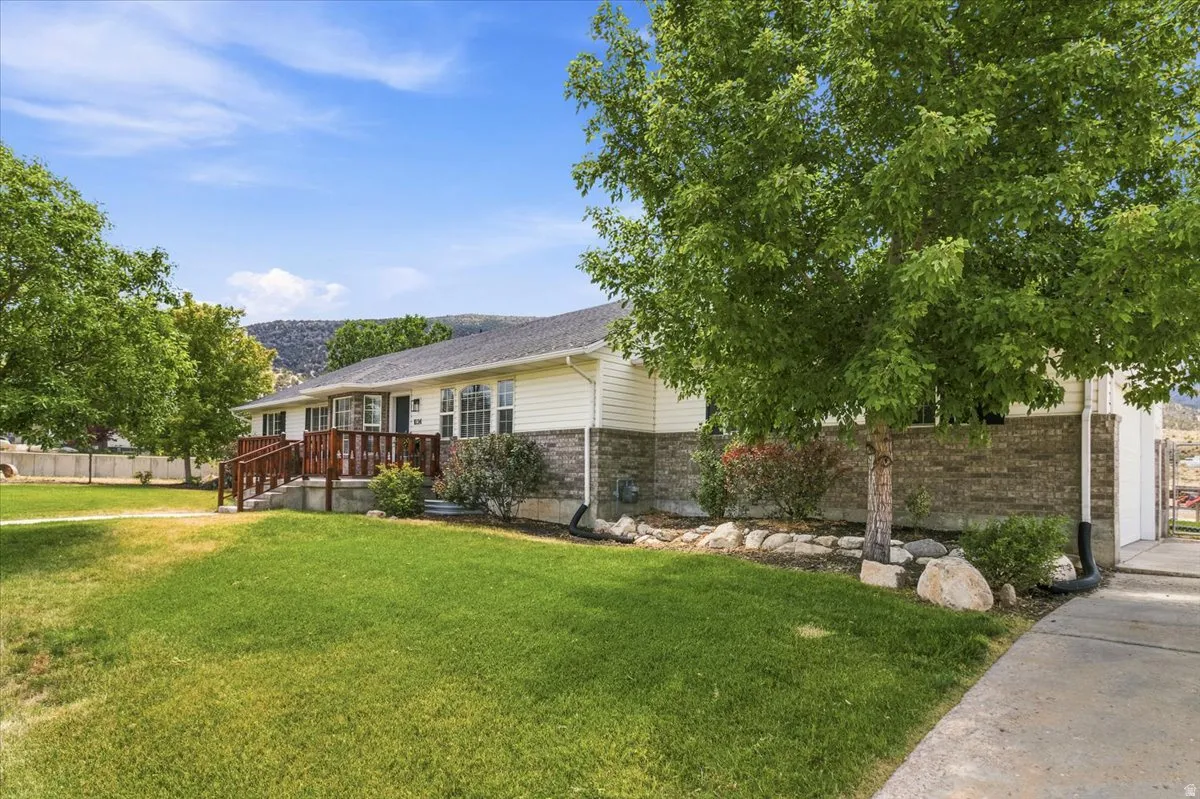 Ranch-style exterior featuring a prominent brown brick facade, light siding, and a dark shingled roof