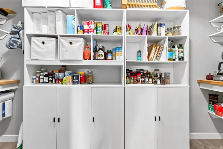 Built-in white cabinetry featuring open shelving, enclosed storage, and a light-colored countertop surface