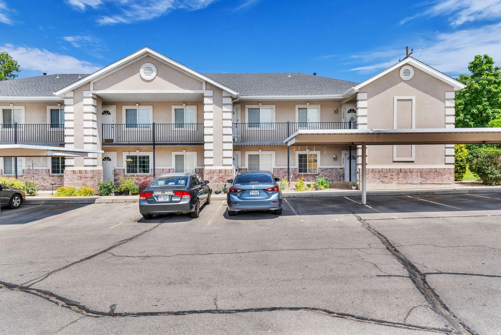 Multi-level building exterior featuring a neutral stucco finish with contrasting stone accents