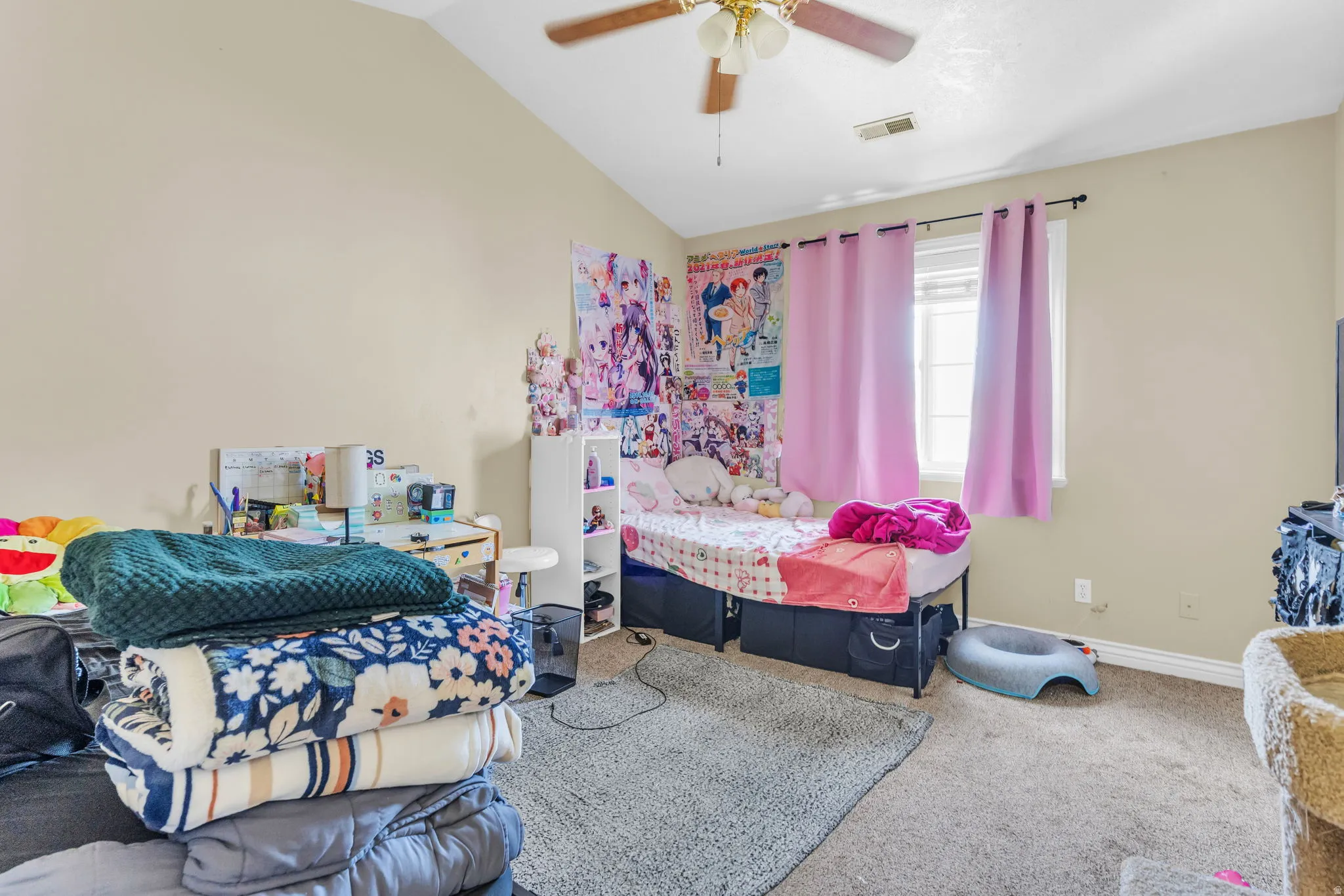 Vaulted ceiling with a ceiling fan and light fixture, featuring a window with blinds and curtains, and carpet flooring