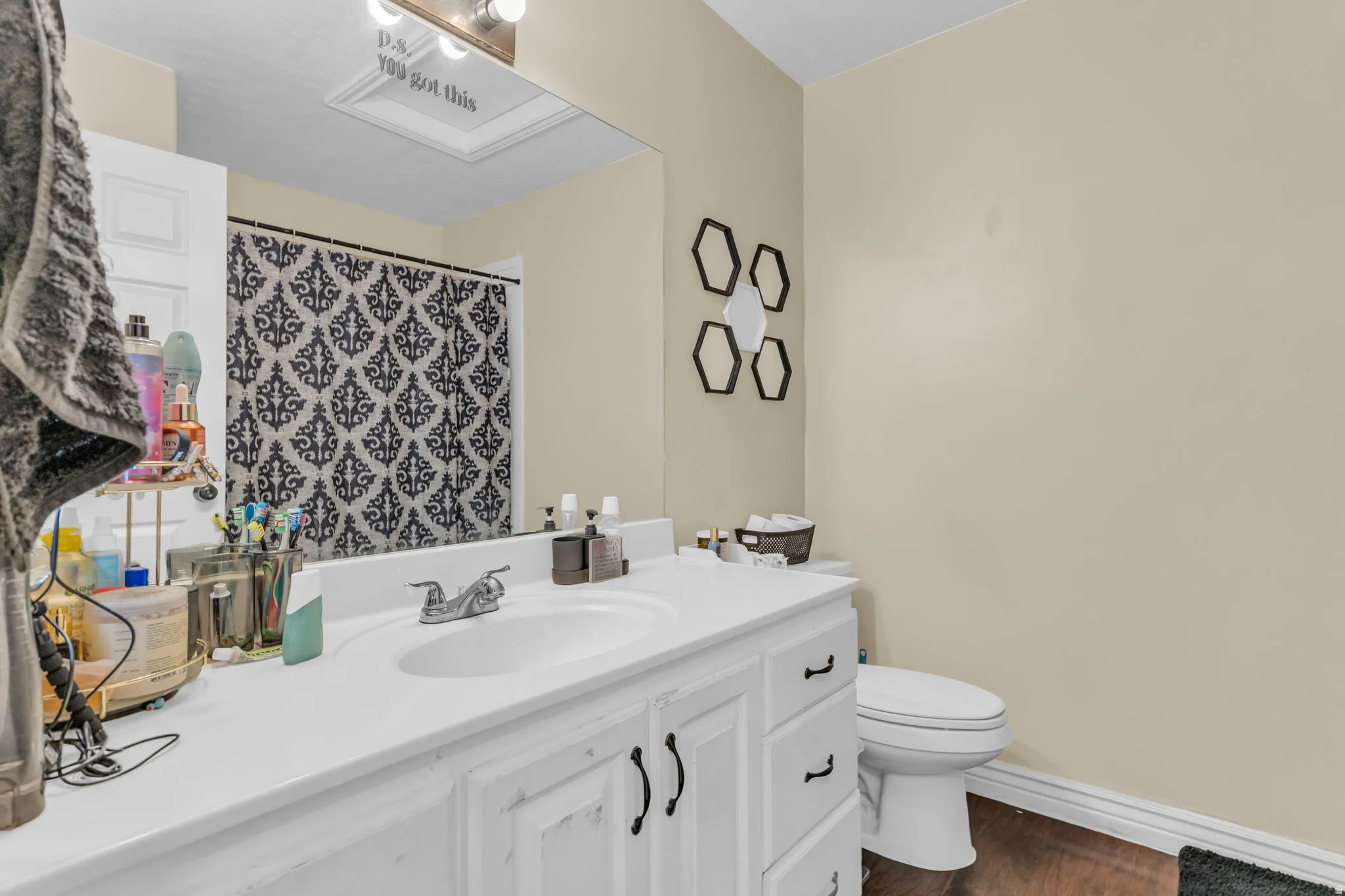Bathroom featuring a vanity with a white countertop, an integrated sink, and white cabinetry with black hardware