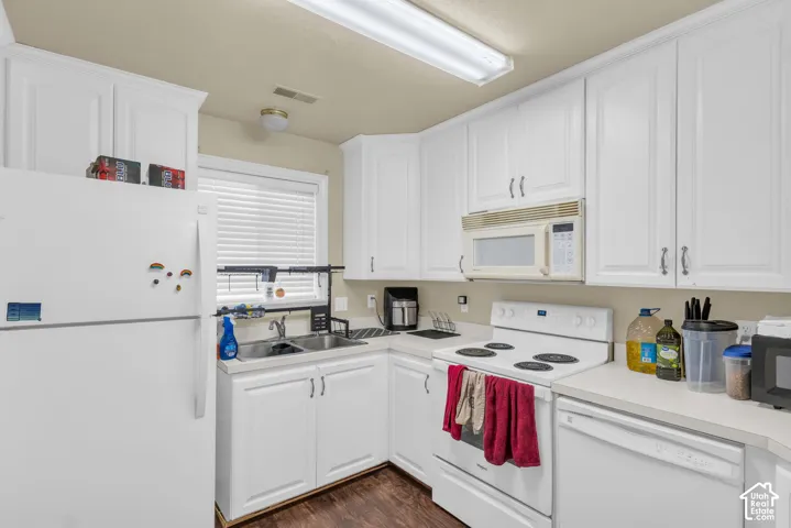 Kitchen with white cabinetry, a double basin sink, and wood-finish flooring