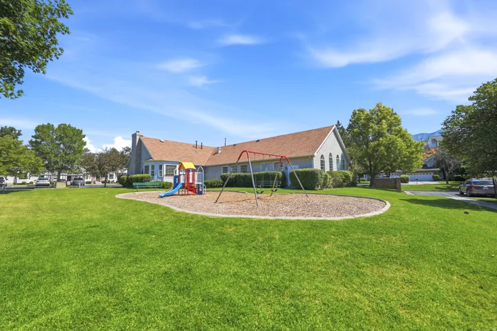 Expansive green space featuring a playground with swings and a slide