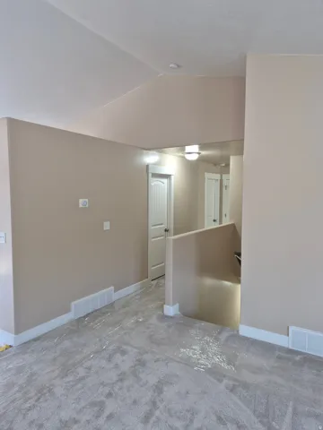 Interior space featuring plush gray carpeting, neutral wall paint, and white baseboards