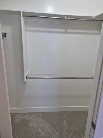 Built-in closet organization system featuring upper and lower chrome hanging rods