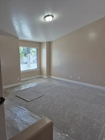 Spacious room featuring neutral carpeting and light-toned walls