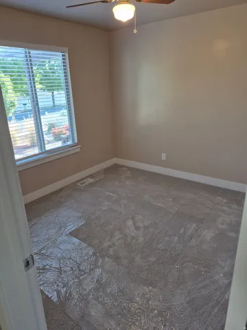 Neutral-toned walls complement the textured gray carpeting