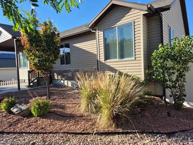 Exterior featuring horizontal siding, a stone facade accent, and a covered entry with railings