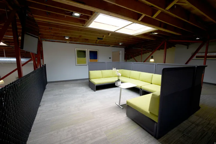 Open loft area featuring exposed wood ceiling beams, a skylight, and recessed lighting