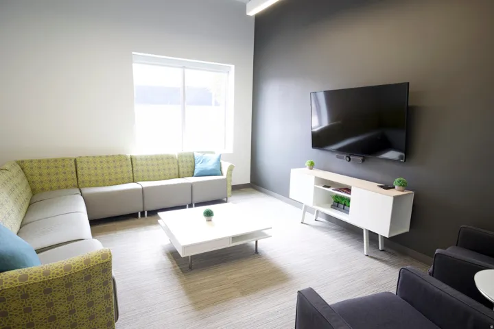 Open-concept room featuring a large window, recessed ceiling lighting, and light-toned carpet flooring