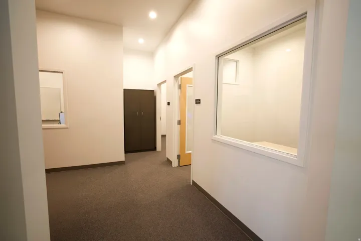 Interior corridor featuring recessed lighting, light-colored walls, and gray carpet flooring