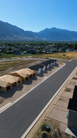 New construction development featuring a paved street, mountain backdrop, and multiple building sites