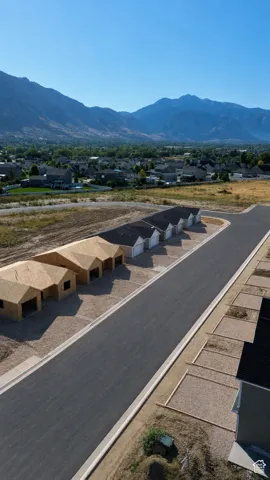 New construction development featuring a paved street, beautiful mountain backdrop, and multiple building sites