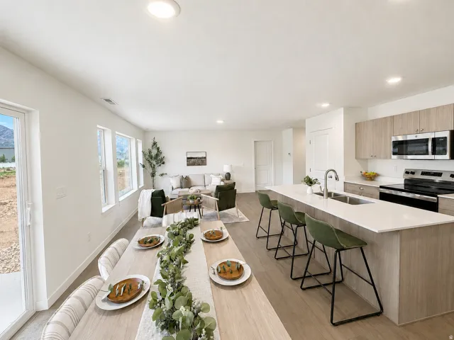 Open-concept living space featuring wood-finish flooring, recessed lighting, and expansive windows