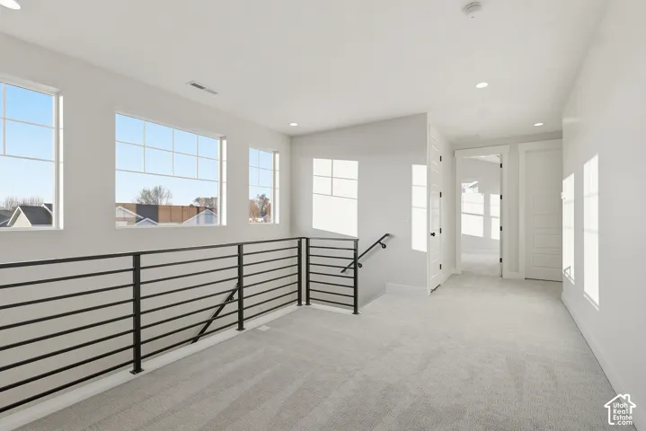 Spacious upper-level landing featuring a contemporary black metal horizontal railing
