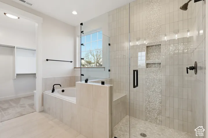 Contemporary bathroom featuring a spacious walk-in shower with stone pebble tile accents, a built-in shower bench, and matte black fixtures