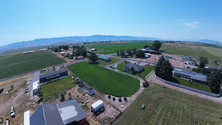 Expansive land parcel featuring open fields, distant mountains, and a clear blue sky