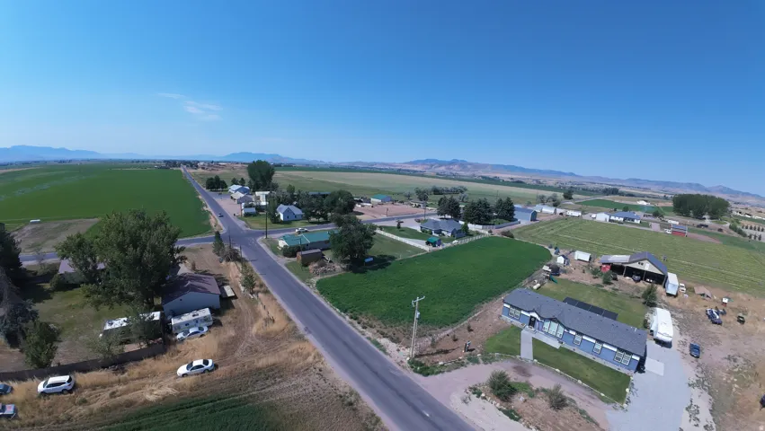 Expansive rural property featuring a long driveway, a detached outbuilding, and significant open land