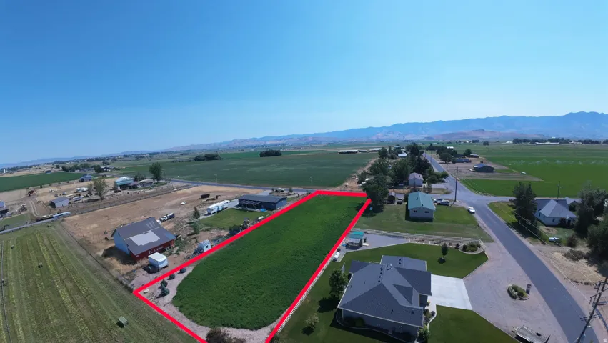 Expansive agricultural land featuring a verdant field, bordered by a clear property line