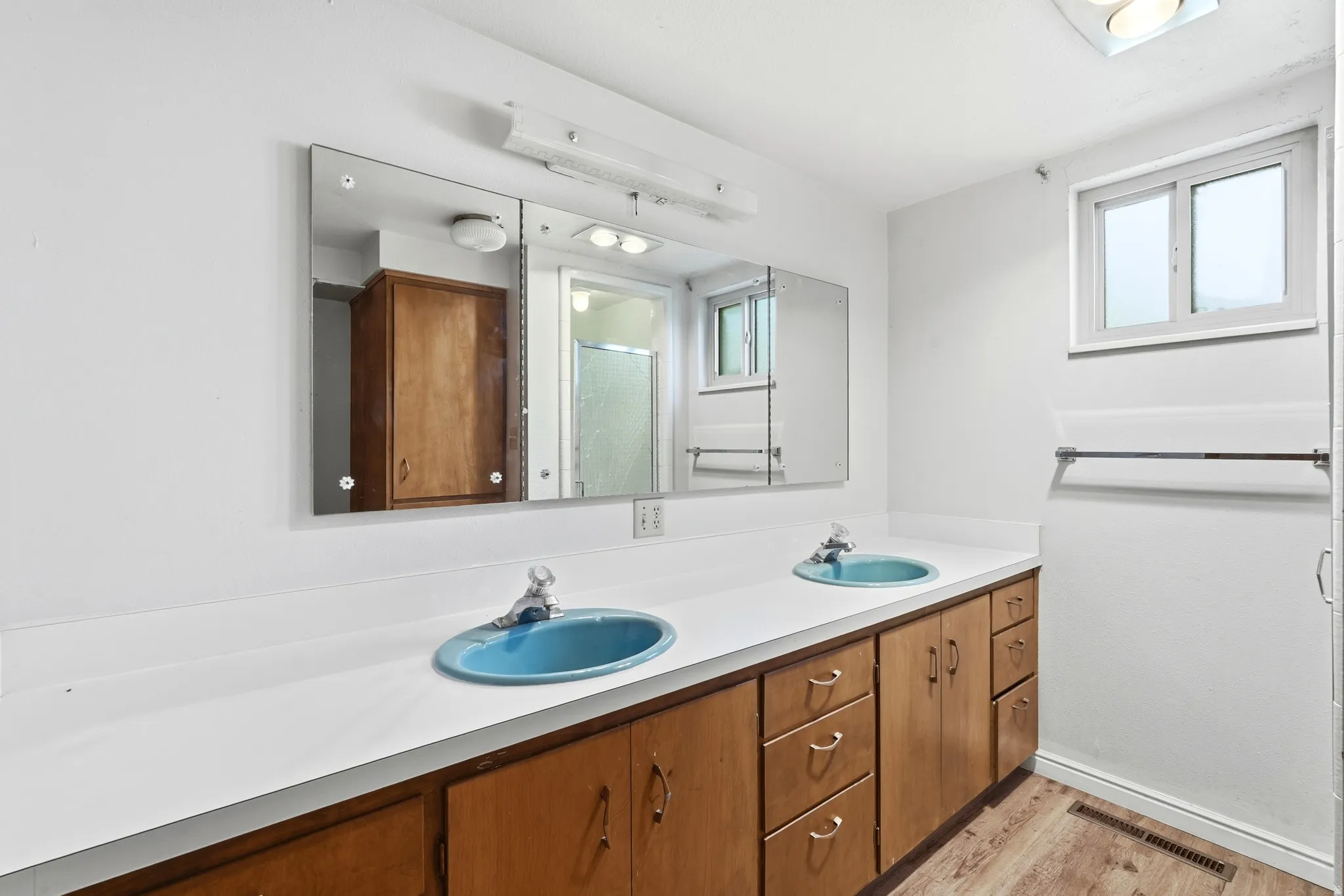 Dual basin vanity with a white countertop and wood-finish cabinetry