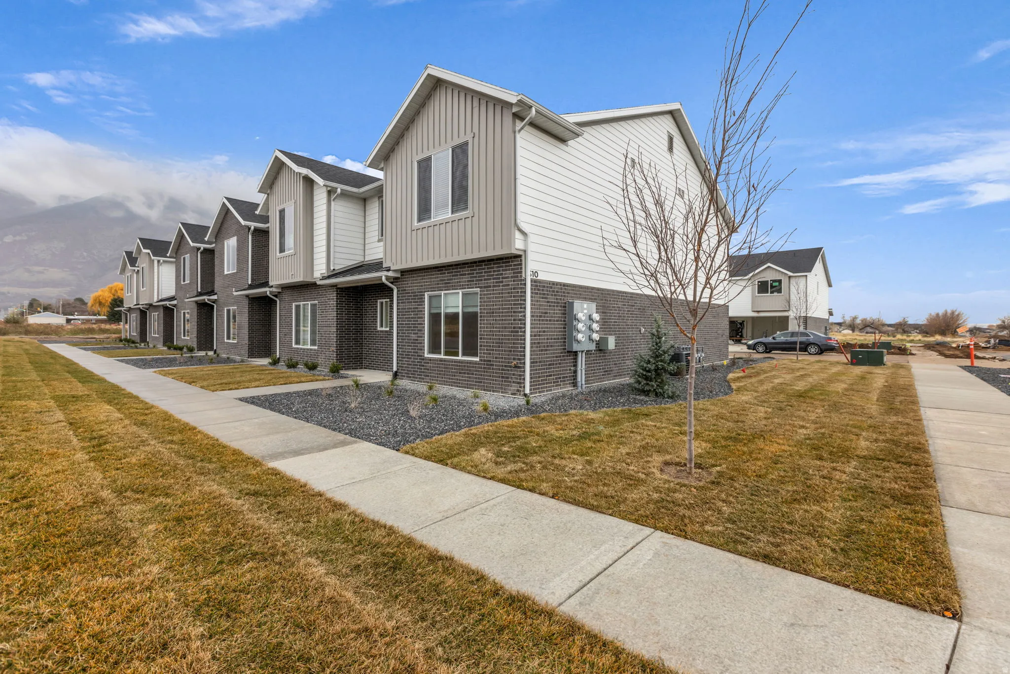 Row of modern townhomes featuring a contemporary exterior with multi-toned siding and brick accents