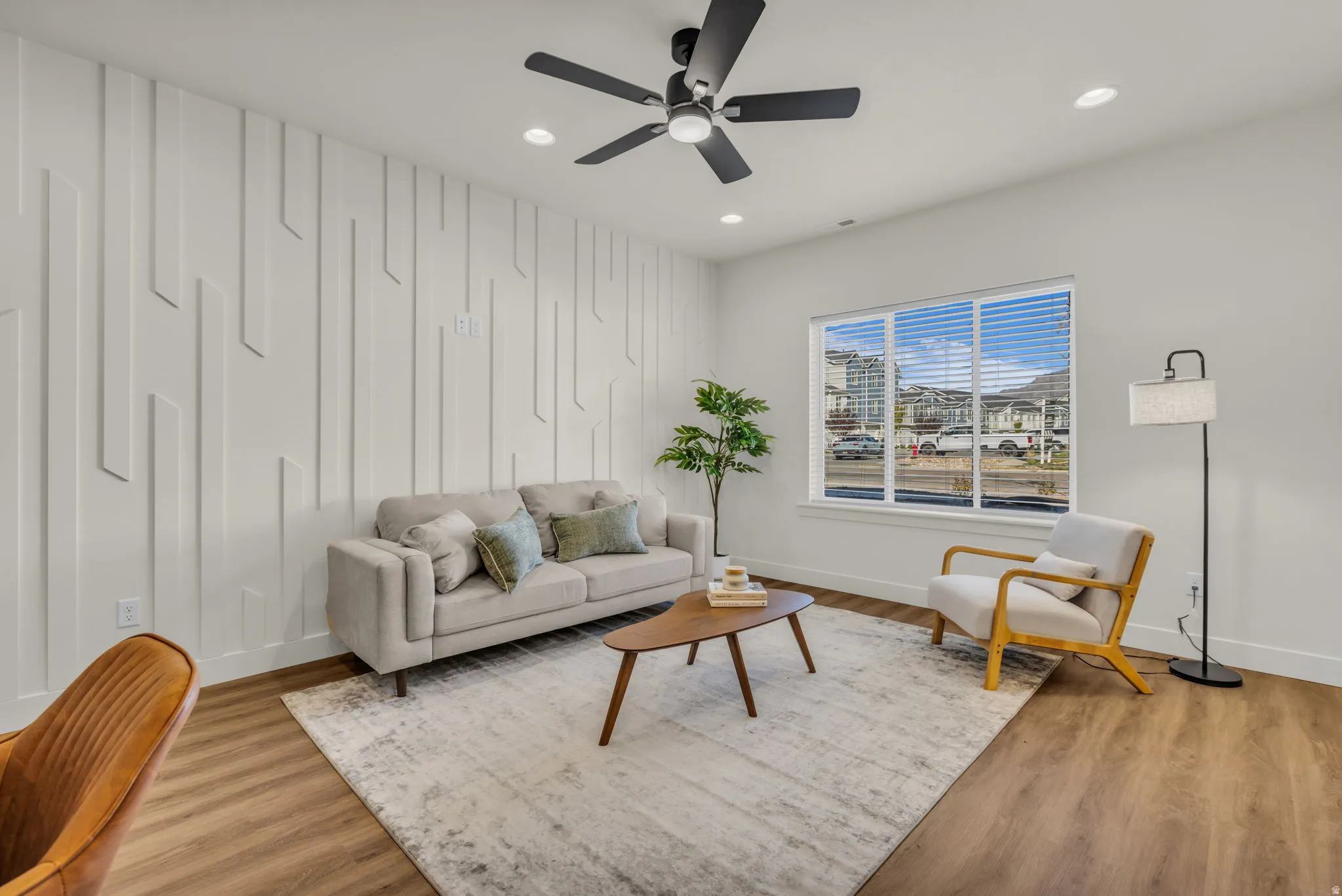 Accent wall with geometric paneling, recessed lighting, and a ceiling fan