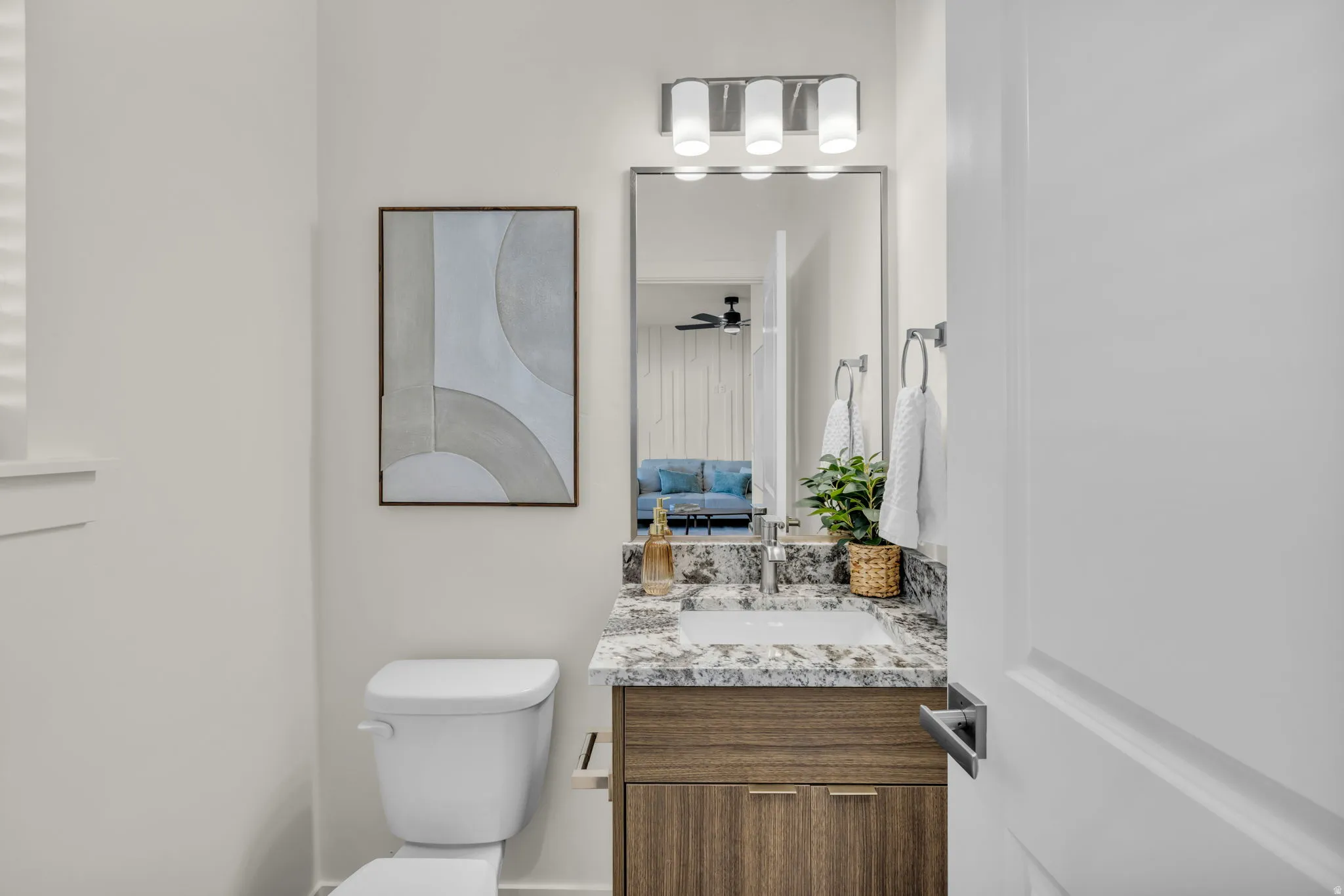Bathroom featuring a wood-finish vanity with a granite countertop and an undermount sink