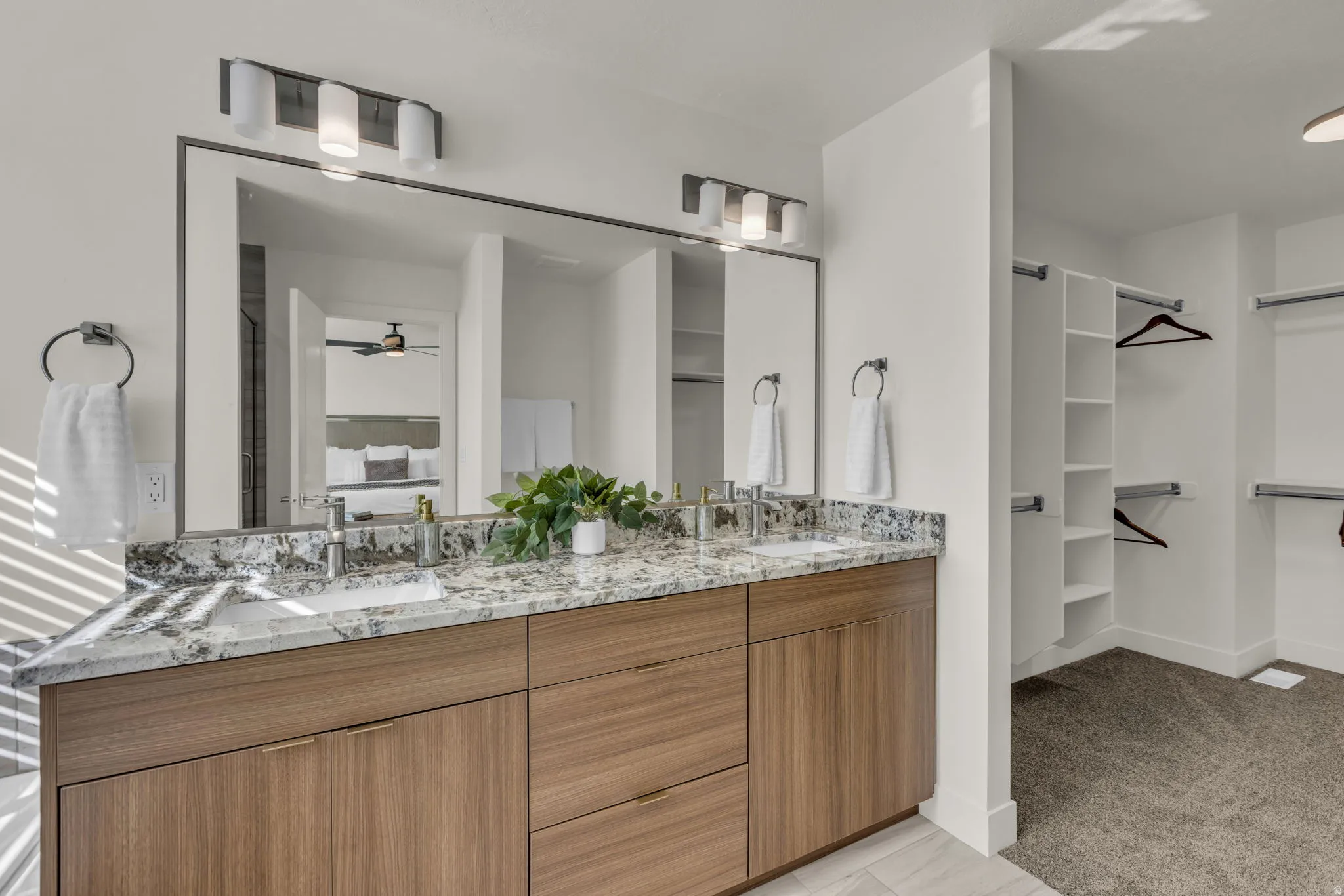 Bathroom vanity featuring dual under-mount sinks, a stone countertop, and wood-finish cabinetry