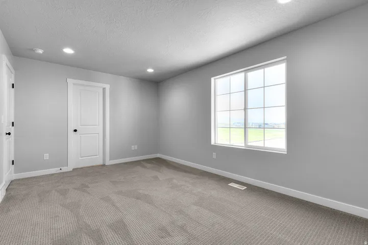 Spacious room featuring neutral grey walls and a large multi-pane window