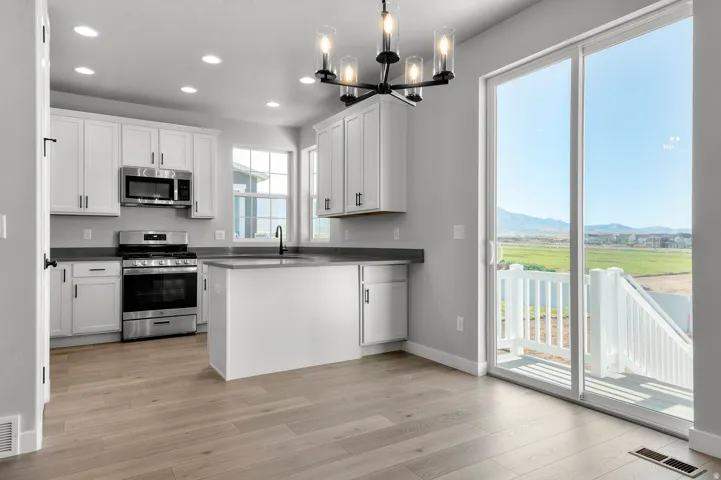 Modern kitchen featuring white cabinetry, stainless steel appliances, and dark countertops