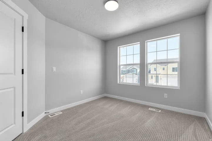 Room with light gray walls, white trim, and light gray patterned carpeting