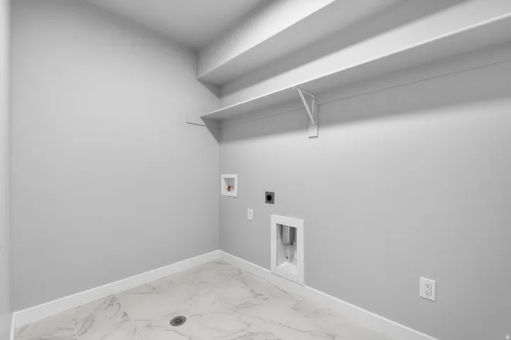 Utility room with light gray walls and white baseboards