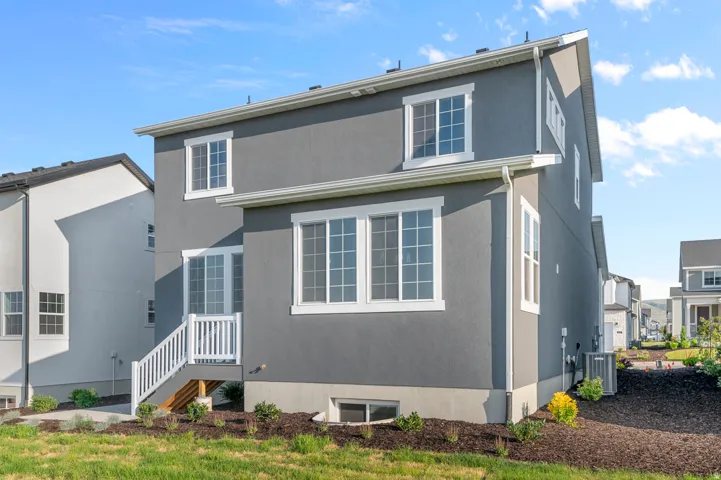 Contemporary gray stucco exterior featuring white trim windows and a white railing staircase