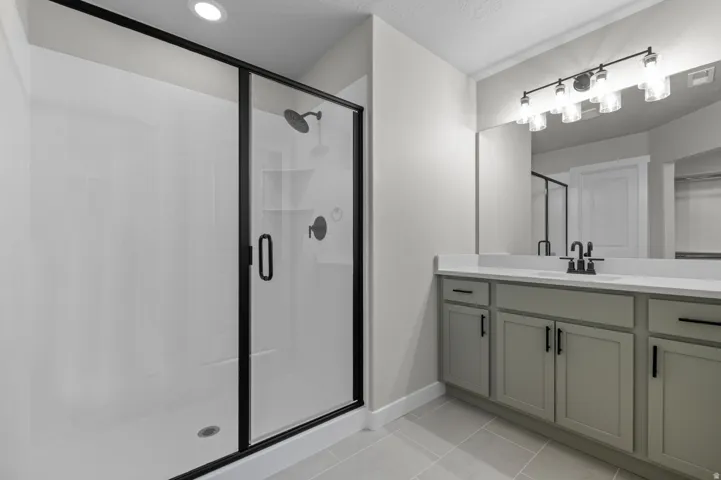 Contemporary bathroom featuring a spacious shower with black-framed glass enclosure, two built-in shower heads, and matte black fixtures