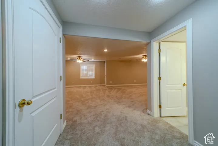 Carpeted room featuring an arched doorway, recessed lighting, and a window with plantation shutters