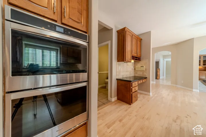 Stainless steel double wall ovens integrated into wood cabinetry